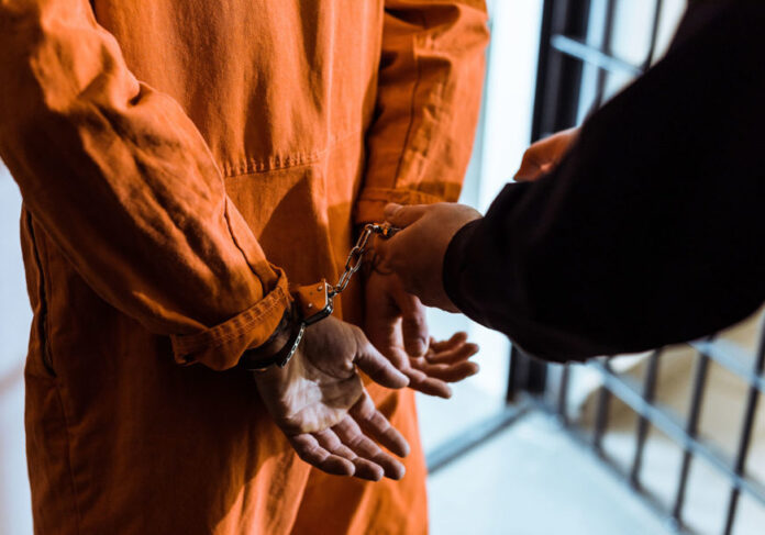 Cropped,Image,Of,Prison,Officer,Wearing,Handcuffs,On,Prisoner